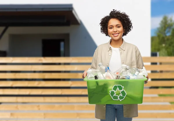 Sonriente mujer sosteniendo caja de plástico con residuos — Foto de Stock