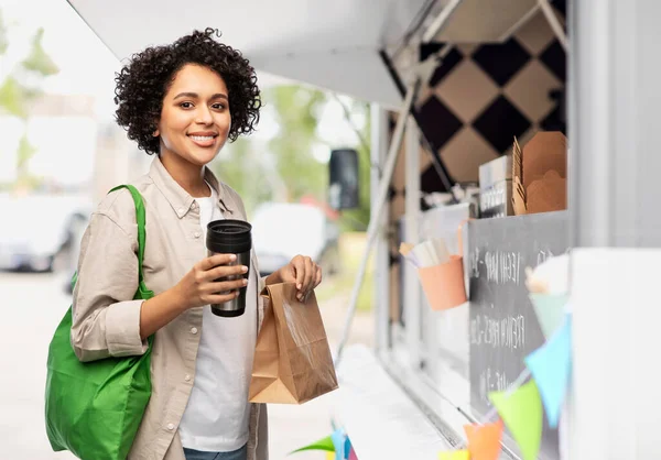 Happy woman with thermo cup, paper bag and shopper — Stock Photo, Image