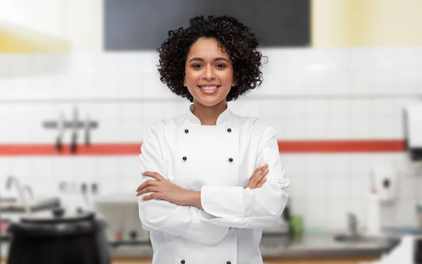 Glimlachende vrouwelijke chef-kok in witte jas op keuken — Stockfoto