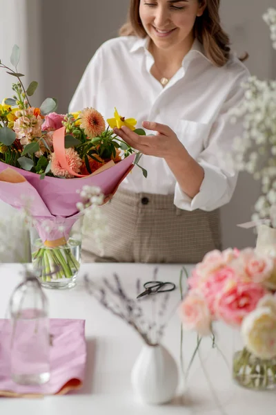 Mulher feliz ou artista floral com flores em casa — Fotografia de Stock