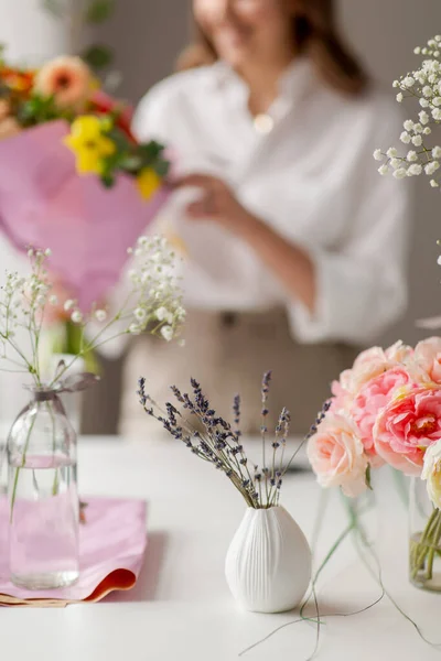 Lavendel blomster i vase og blomsterkunstner - Stock-foto