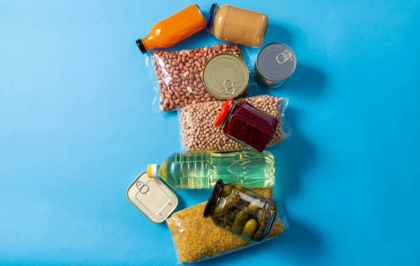Närbild av förpackad mat på blå bakgrund — Stockfoto