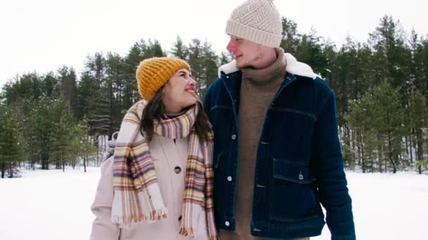 Feliz casal sorrindo andando na floresta de inverno — Vídeo de Stock