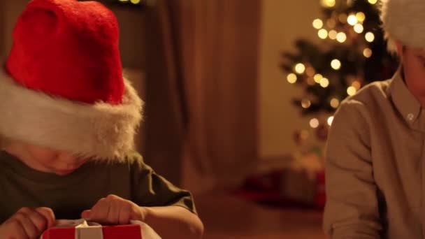 Boldog gyerekek nyitó karácsonyi ajándékok otthon — Stock videók