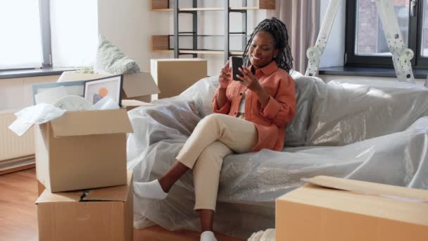 Gelukkig vrouw met smartphone verhuizen naar nieuw huis — Stockvideo