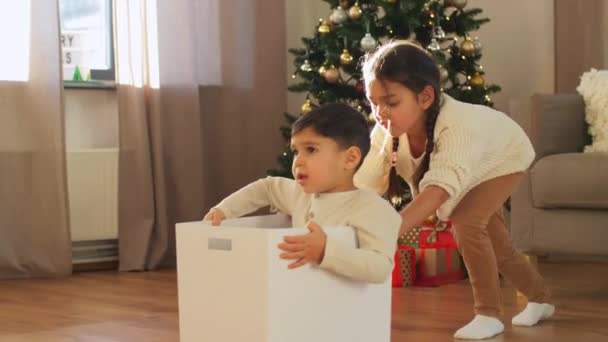 Crianças brincando com caixa em casa no Natal — Vídeo de Stock