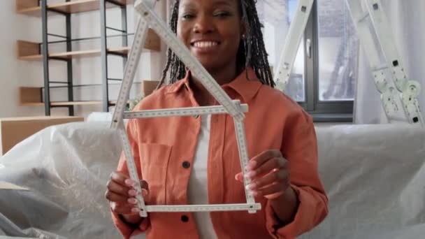 Šťastná žena s pravítkem ve tvaru domu doma — Stock video