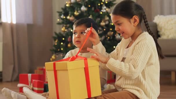 Χαρούμενα παιδιά ανοίγουν χριστουγεννιάτικα δώρα στο σπίτι — Αρχείο Βίντεο