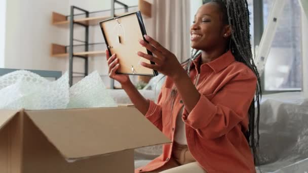 Šťastná žena vybaluje krabice a stěhuje se do nového domova — Stock video