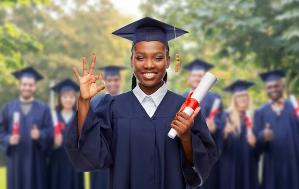 Kobieta absolwentka z dyplomem pokazuje ok — Zdjęcie stockowe