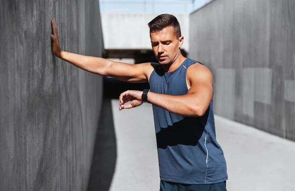 Young man with fitness tracker on city street — Stock Photo, Image