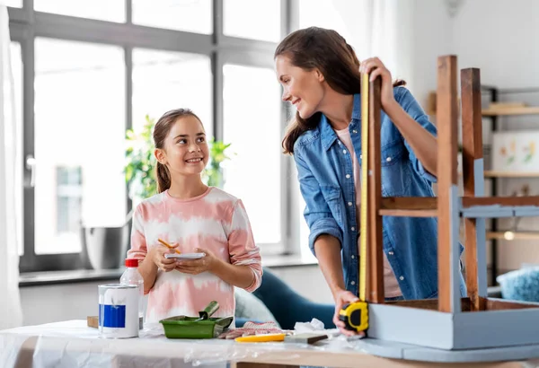 Madre e hija con regla midiendo mesa vieja —  Fotos de Stock