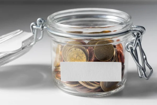 Монеты в стеклянную банку для пожертвования или экономии — стоковое фото
