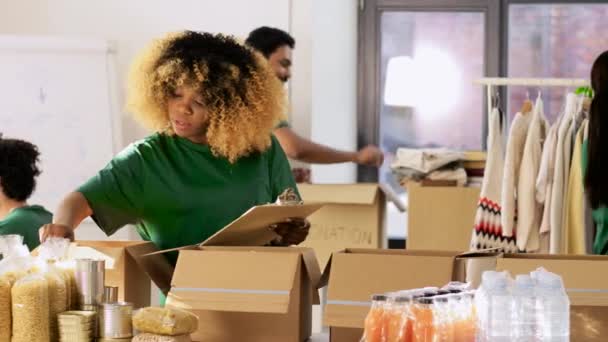 Grupo de voluntarios empacando comida en cajas de donaciones — Vídeos de Stock