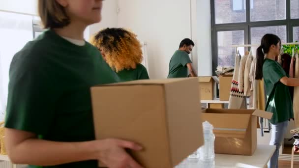 Groep vrijwilligers die voedsel in donatiedozen verpakken — Stockvideo