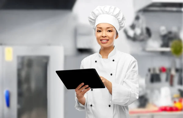 Sorridente chef feminino com tablet pc na cozinha — Fotografia de Stock