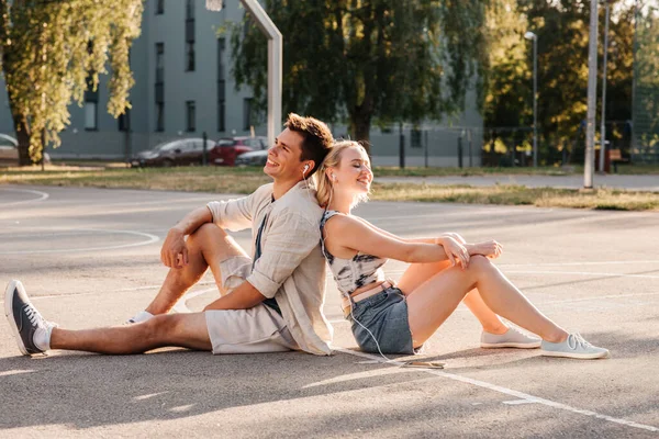 Couple heureux avec smartphone et écouteurs en ville — Photo