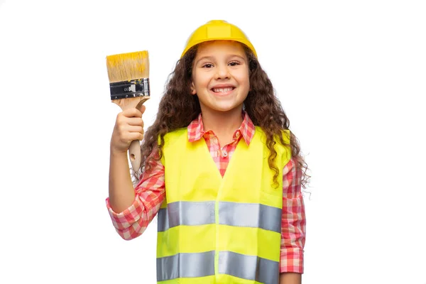 Girl in helmet and safety vest with paint brush — Stock Photo, Image