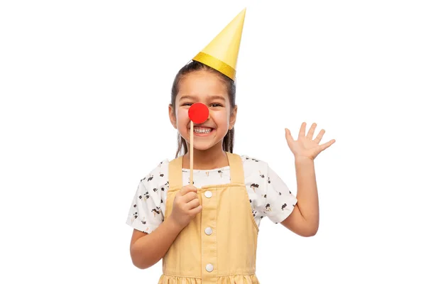 Dívka v narozeninové párty klobouk s červeným klaunským nosem — Stock fotografie