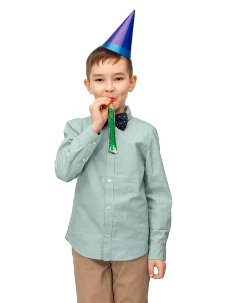 Glimlachende jongen in verjaardagsfeestmuts met blower — Stockfoto