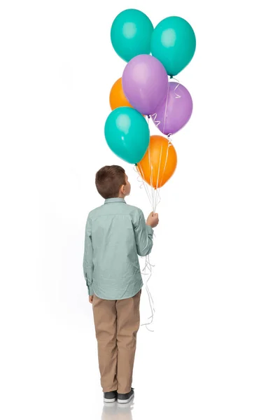 Liten pojke i födelsedagskalas hatt med ballonger — Stockfoto