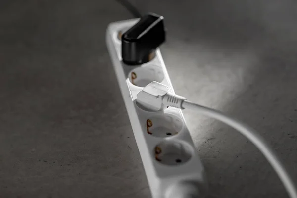 Close up of socket with plugs and charger on floor — Stock Photo, Image