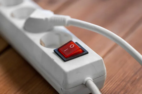 Close up of socket with plugs and charger on floor — Stock Photo, Image