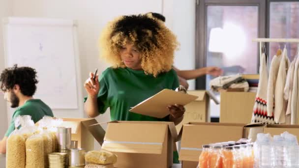 Grupo de voluntários embalando alimentos em caixas de doação — Vídeo de Stock