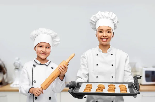 Жіночий шеф-кухар і дівчина з печивом і прокатним штифтом — стокове фото