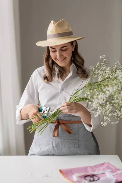 Happy woman making bunch of flowers at home — Stock Photo, Image