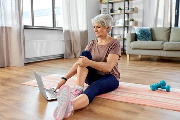 Mujer feliz con el ordenador portátil haciendo ejercicio en casa — Foto de Stock