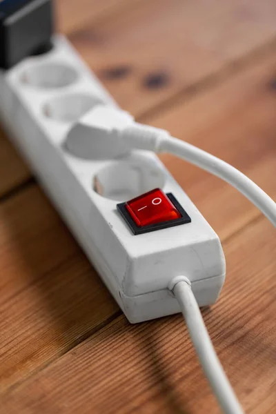Close up of socket with plugs and charger on floor — Stock Photo, Image