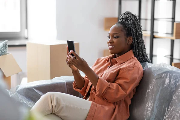Kvinna med smartphone och lådor flyttar till nytt hem — Stockfoto