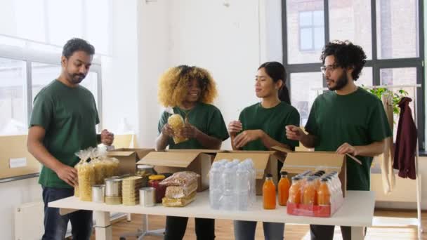 Šťastní dobrovolníci balení potravin v dárcovských krabicích — Stock video