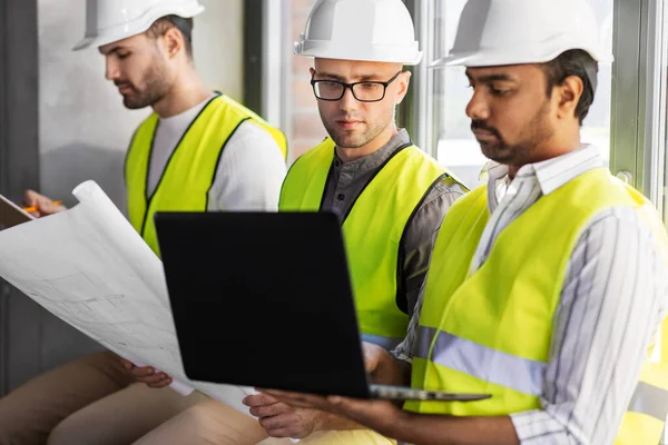 Arquitectos masculinos en cascos trabajando en la oficina — Foto de Stock