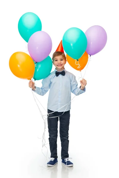 Niño feliz en sombrero de fiesta de cumpleaños con globos — Foto de Stock