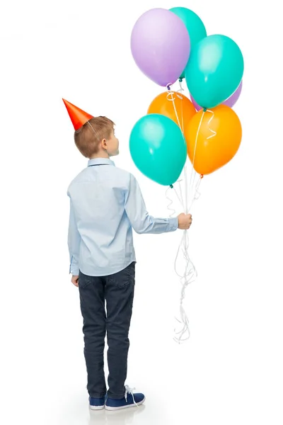 Šťastný chlapec v narozeninové párty klobouk s balónky — Stock fotografie