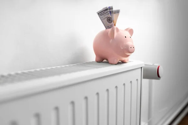 Alcancía con dinero en el radiador en casa — Foto de Stock