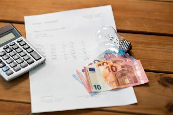 Energierekening, rekenmachine, geld en gloeilamp — Stockfoto