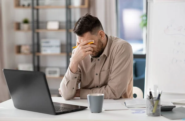 Professor masculino cansado com laptop trabalhando em casa — Fotografia de Stock