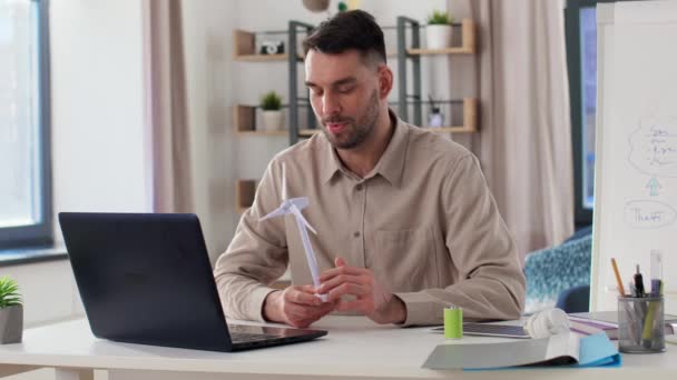 Вчитель чоловічої статі з ноутбуком і вітровою турбіною вдома — стокове відео