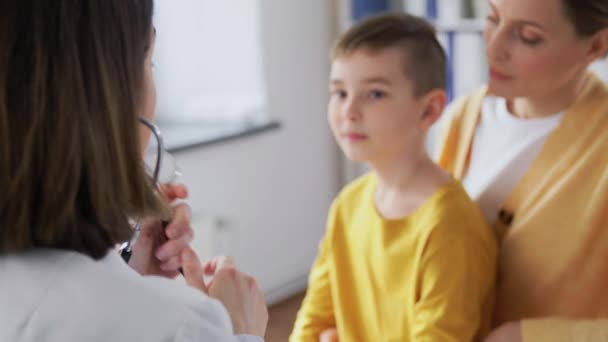 Mor, son och läkare med stetoskop på kliniken — Stockvideo