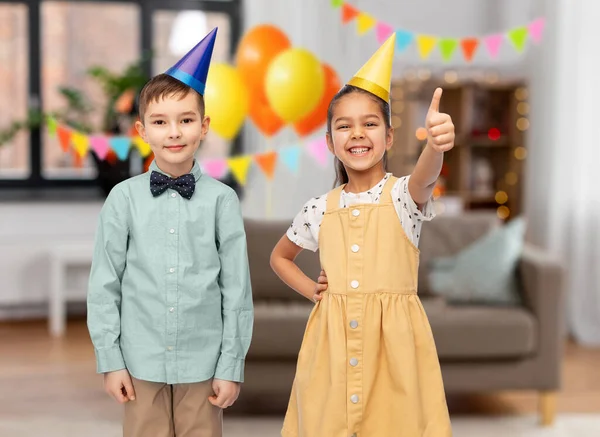 Crianças felizes mostrando polegares para cima na festa de aniversário — Fotografia de Stock