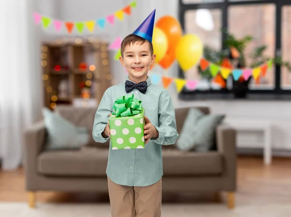 Menino sorridente em chapéu de festa com presente de aniversário — Fotografia de Stock