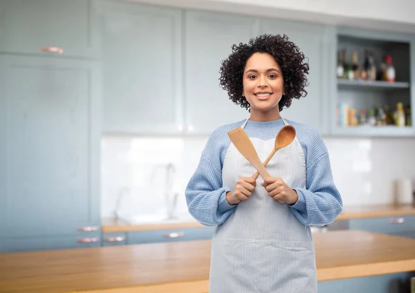 Önlüklü kadın, mutfakta kaşık ve spatula. — Stok fotoğraf