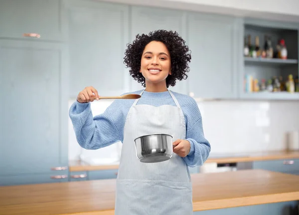 Donna felice cucina il cibo in pentola in cucina — Foto Stock