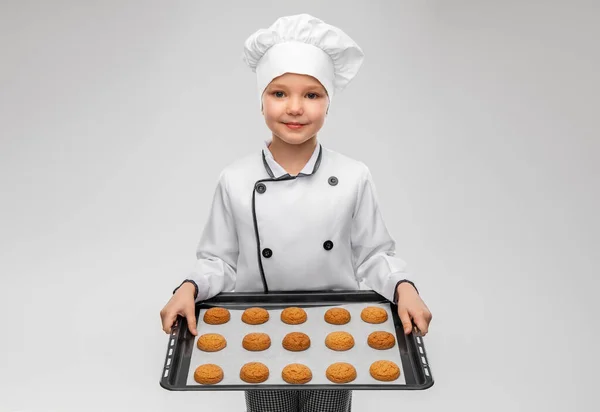 Niño en toque sosteniendo bandeja para hornear con galletas —  Fotos de Stock