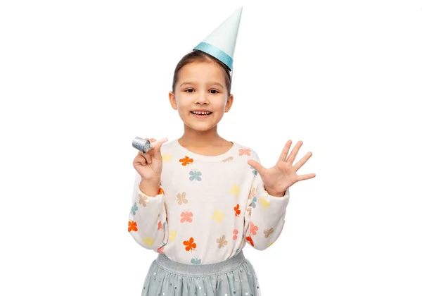 Leende flicka i födelsedagskalas hatt med fläkt — Stockfoto