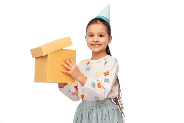 Chica sonriente en fiesta sombrero regalo de cumpleaños de apertura —  Fotos de Stock