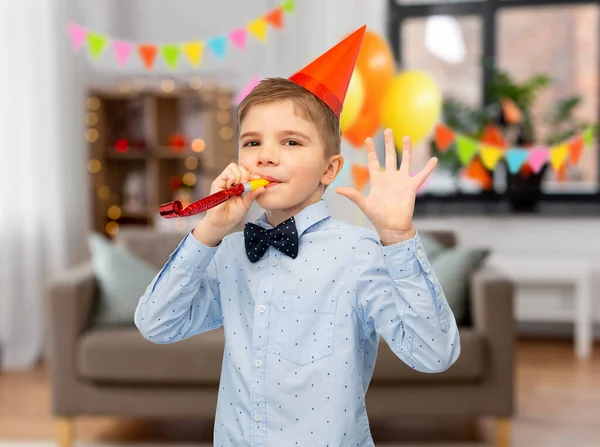 Menino sorridente em chapéu de festa de aniversário com ventilador — Fotografia de Stock